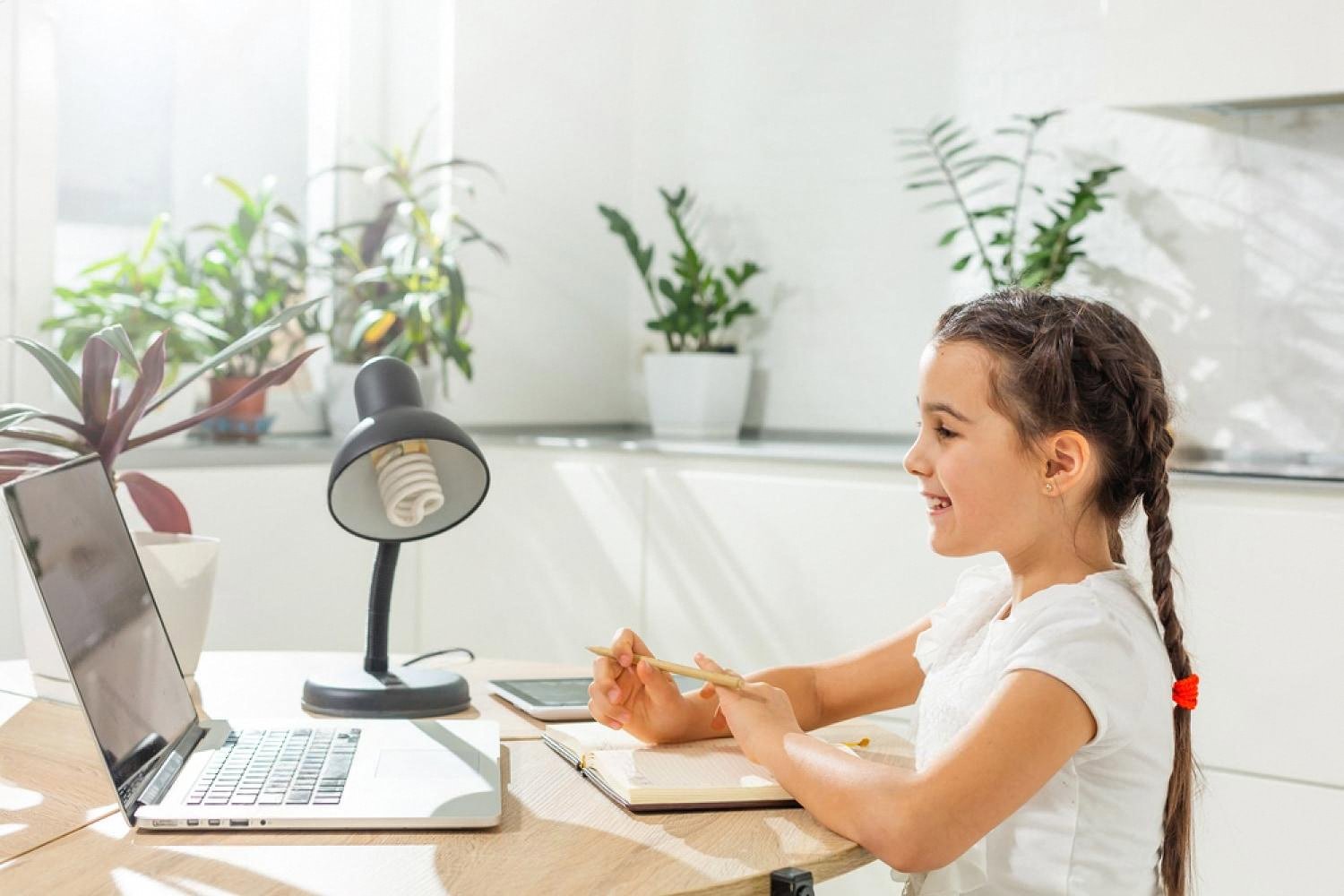 A young girl studying calmly at a bright desk, showing how a safe environment supports focused learning