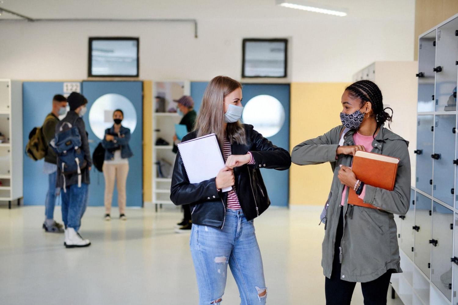 Two students greeting each other safely in a school corridor, illustrating health-conscious habits in UAE classrooms