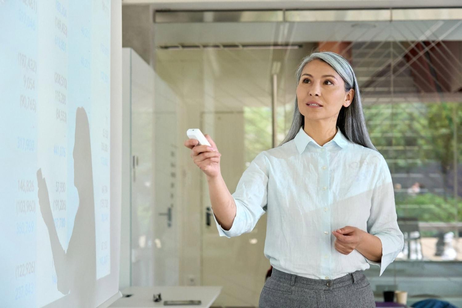 Senior female executive presenting financial data to her team in a modern Dubai office
